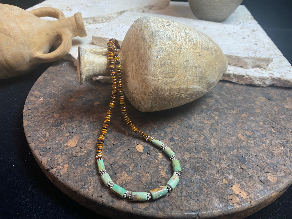 Dirty, natural blue-green turquoise beads teamed with saucer-cut natural tigers eye. Sterling silver clasp and detailing. This statement necklace has a distinctive Southwest vibe and is designed to be worn by men or women. Length 49 cm