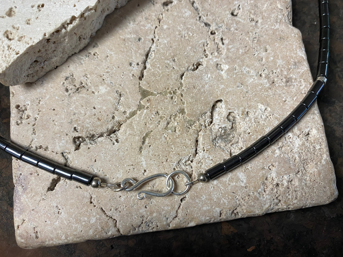Hematite unisex necklace of tube beads highlighted with sterling silver detailing and finished with a sterling silver hook clasp. Can be worn by men or women.  Natural hematite necklace. Length 44.4 cm (17.5")