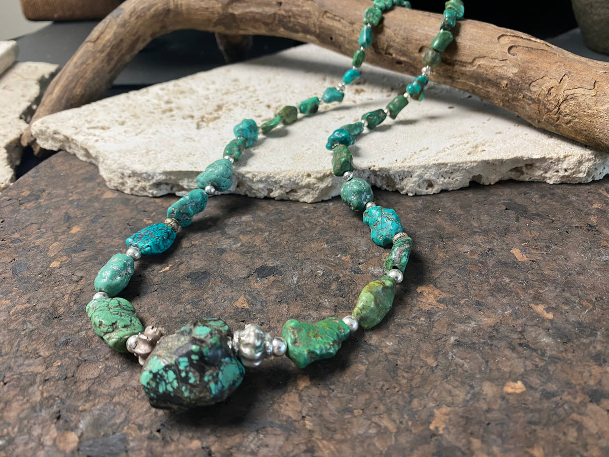 A unique necklace crafted from graduated antique Tibetan turquoise and vintage silver beads, highlighted with sterling silver spacer beads. These beautiful natural stones range in colour from mid to dark blue-green and are all antiques in their own right. The best turquoise we've ever found.  This long tribal necklace can be worn by either men or woman. Total length 62.7 cm