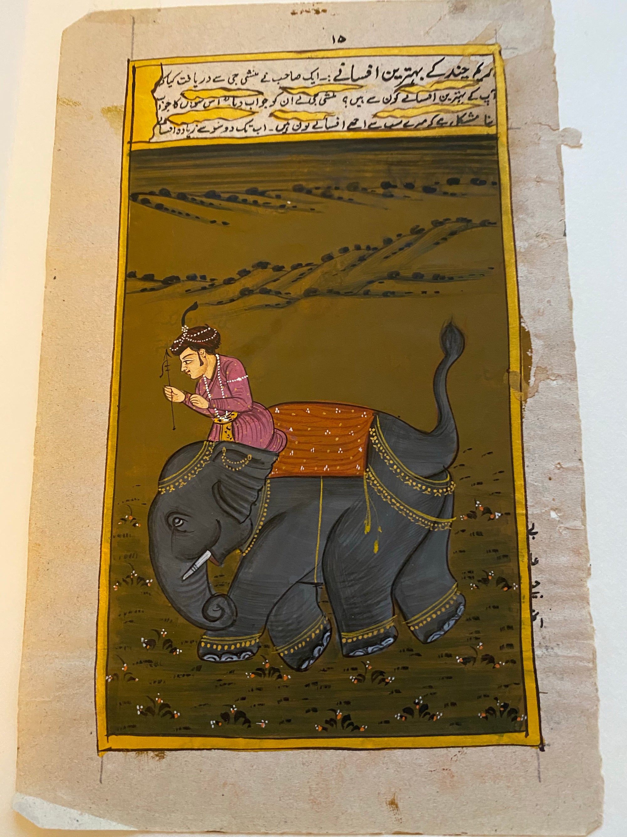 An original painting in the Mogul style, depicting a well-to-do young man on his way on elephant back to see his beloved