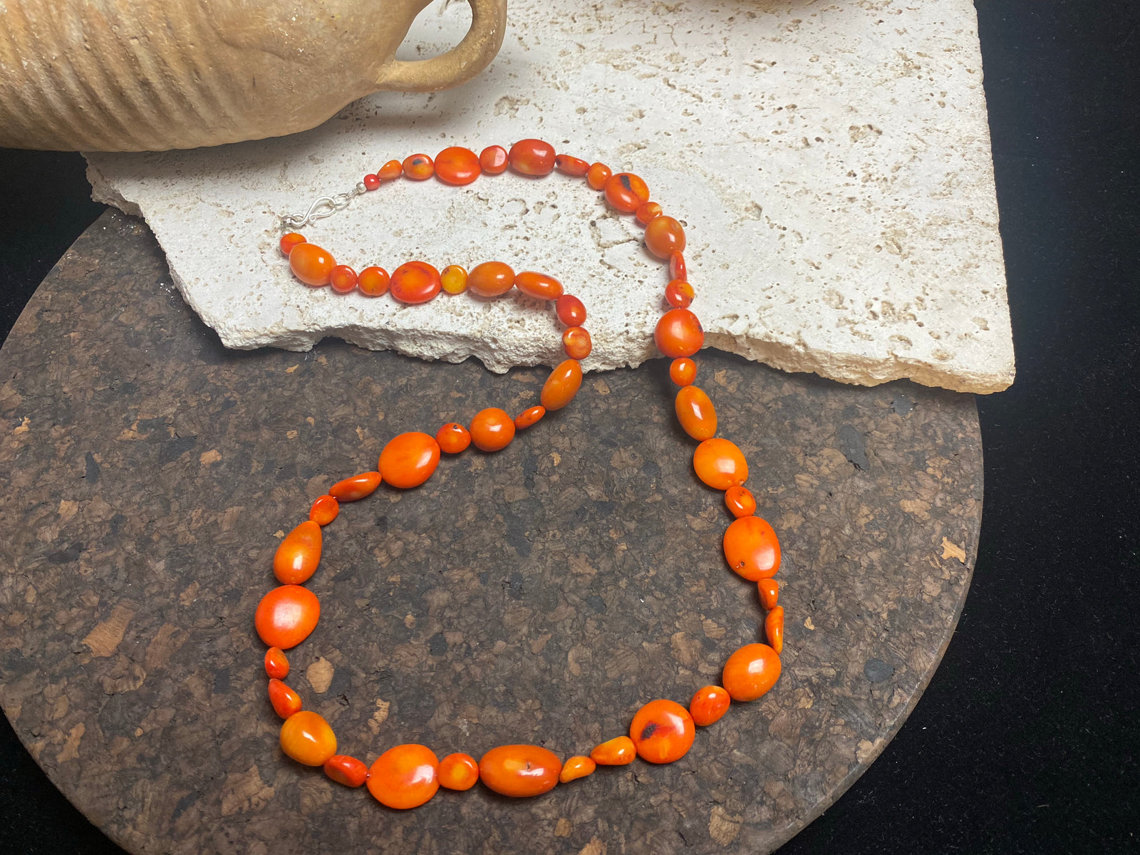 Bold and long red bamboo coral necklace featuring orange-red coral boulder beads of different sizes finished with sterling silver clasp and hook, length 66.5 cm.