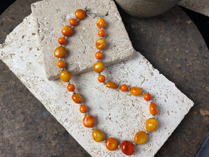 Bold coral necklace featuring orange red coral boulder beads of different sizes finished with sterling silver detailing