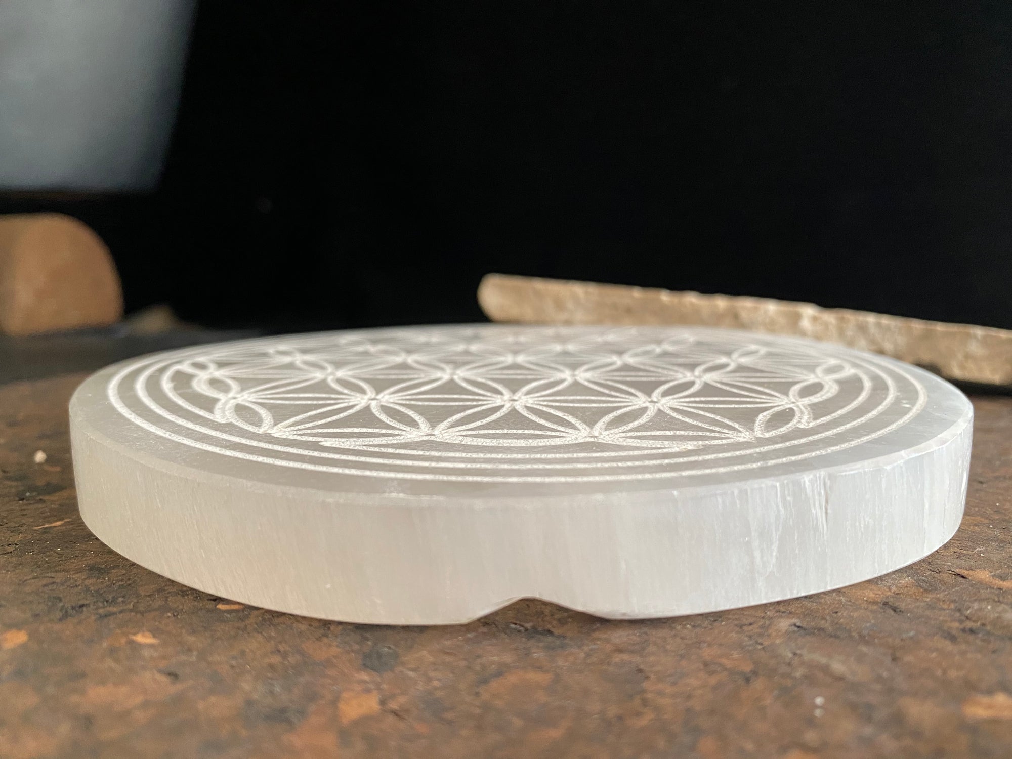 Large, engraved selenite charging plate or stand for the display of crystals and other important objects. Diameter 14.8 cm
