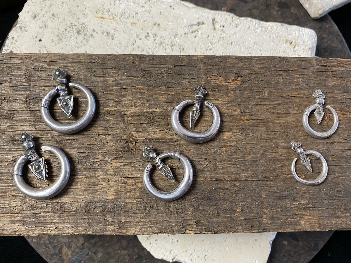 Three pairs of tribal silver earrings called Bent Arrow. Worn pushed sideways through the ear by Yao women. High grade silver, they can only be worn with an extended piercing