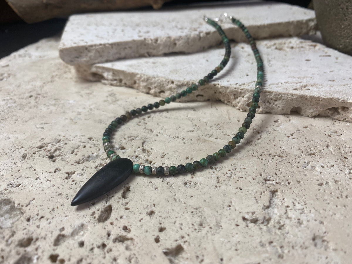 Fine unisex necklace of round natural stone beads, highlighted with Karen hill tribe sterling silver "eye beads" and a long pendant of unpolished onyx. The effect is simple and stunning. Finished with sterling silver findings and hook clasp. Length 42 cm