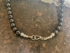 Beautiful unisex hematite necklace of perfectly cut round beads highlighted with a silver cross and sterling silver hook clasp. Can be worn by men or women. Length 50.5 cm