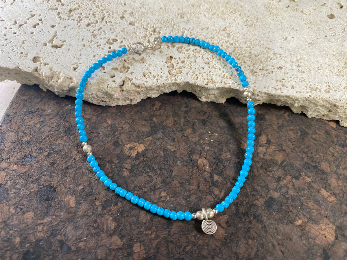 Beach boho anklets featuring turquoise-look dyed howlite and sterling silver charms. Sterling silver clasps and detailing. Designed to sit gracefully around the foot rather than tight to the ankle. Select from three sizes and two styles