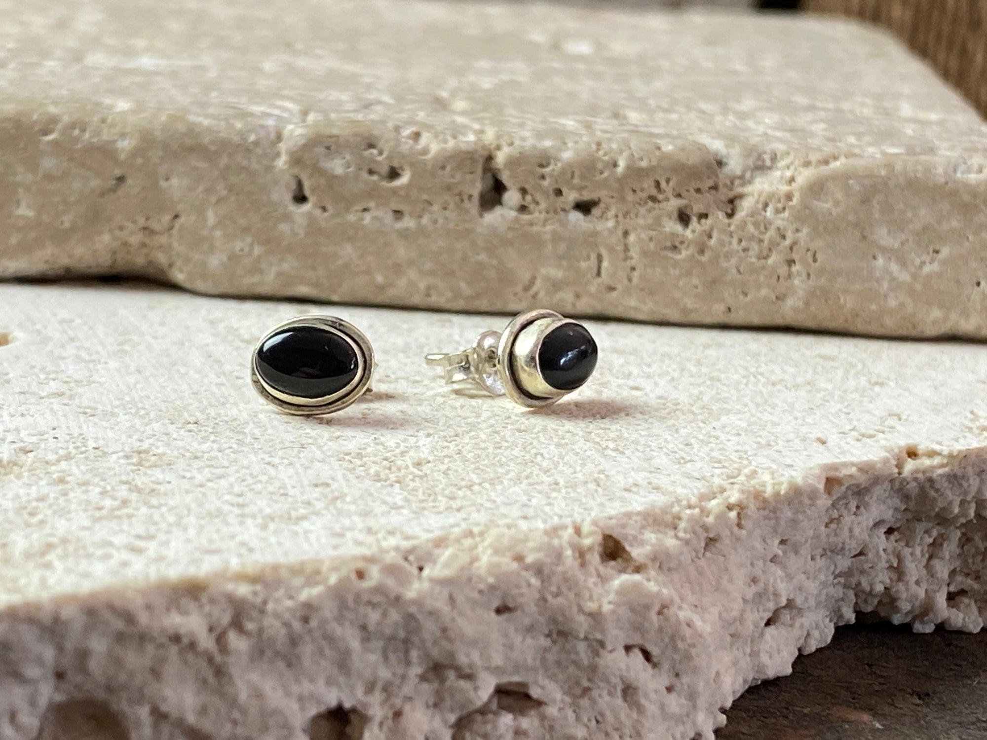 Simple black onyx and sterling silver ear studs with a simple raised bezel setting