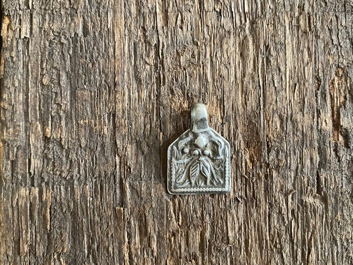 Antique silver amulets representing the Hindu god Kali, in her protective form, and dating from the early 19th - early 20th century.  Measurements: all vary between 1.5 and 2.2 cm in width