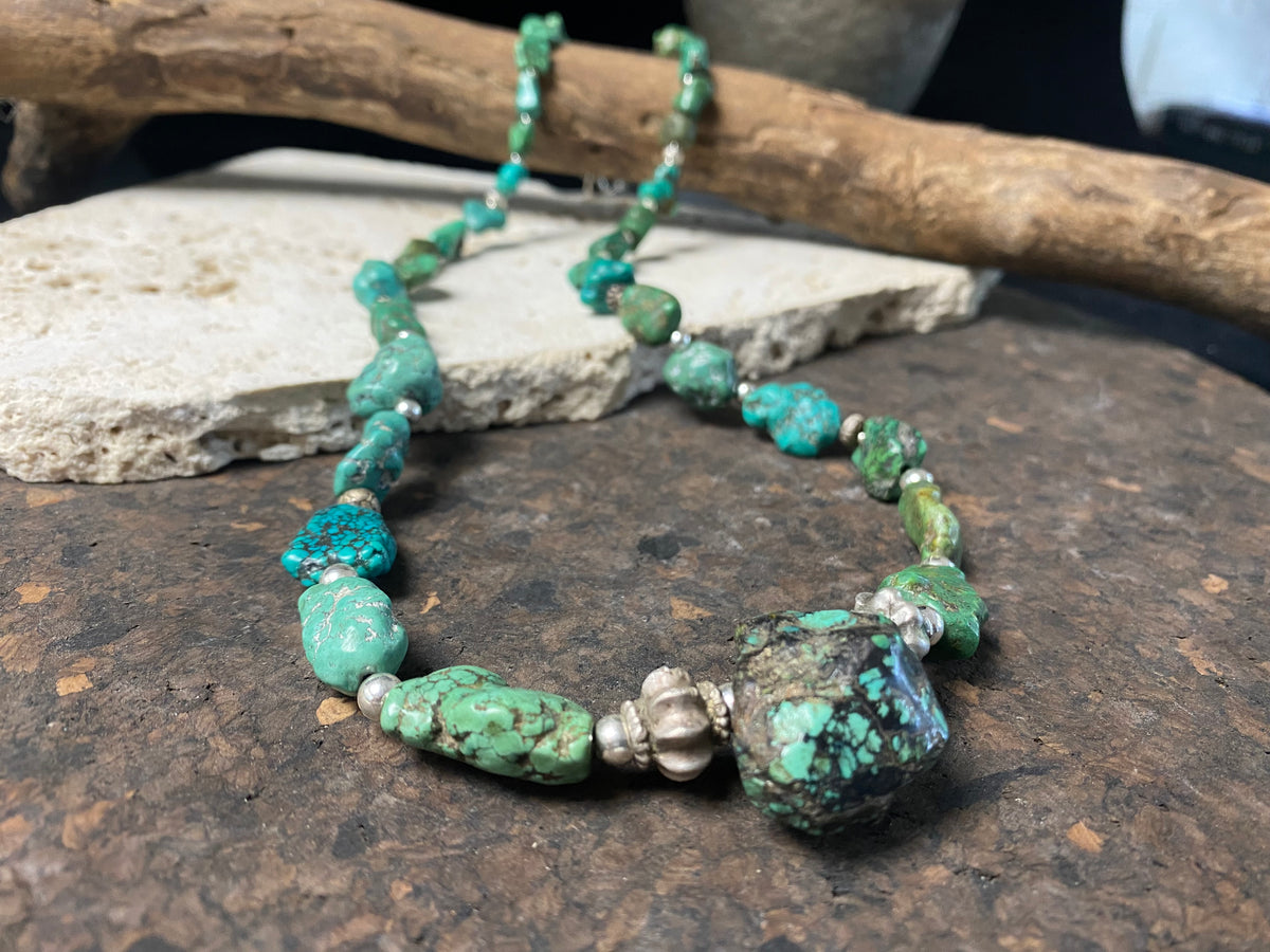 A unique necklace crafted from graduated antique Tibetan turquoise and vintage silver beads, highlighted with sterling silver spacer beads. These beautiful natural stones range in colour from mid to dark blue-green and are all antiques in their own right. The best turquoise we've ever found.  This long tribal necklace can be worn by either men or woman. Total length 62.7 cm