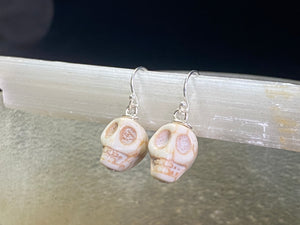 Hand carved from American howlite, these simple skull earrings feature sterling silver hooks.