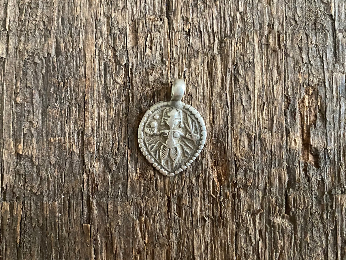 Antique silver amulets representing the Hindu god Kali, in her protective form, and dating from the early 19th - early 20th century.  Measurements: all vary between 1.5 and 2.2 cm in width