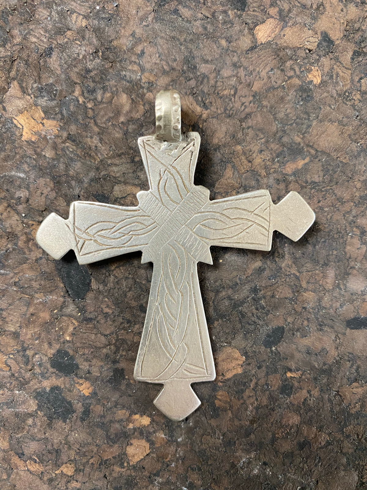 Early 20th century Ethiopian silver cross, most likely cut from a Marie Therese Thaler. Silver, with a simple engraved decoration on each side and light wear at the head of the bail,  total height including bail 7.5 cm (3")