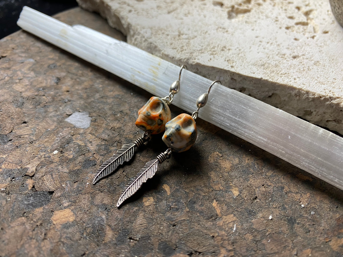 Skull jewelry. Hand carved jasper skull earrings feature sterling silver hooks and feather dangles. 