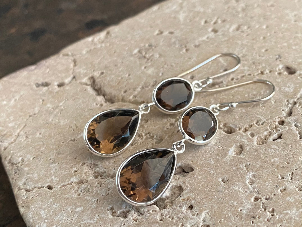 Visually stunning, facet cut drop earrings of facet cut clear or smokey quartz, finished with sterling silver mounts and hooks. The perfect drop earring. Length including hook 5 cm