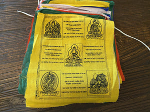 Buddhist prayer flags with the mantra "om mani padme hum" to the Compassionate Buddha. Every time they flutter, all prayers are offered to heaven on your behalf, promoting peace, compassion, strength & wisdom. Hand printed cotton, Nepal. Extra long strings of 5 metres, each flag 20 x 24 cm
