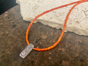 Orange-red coral necklace with sterling silver filigree pendant. Finished with l silver hook clasp. Length 45 cm