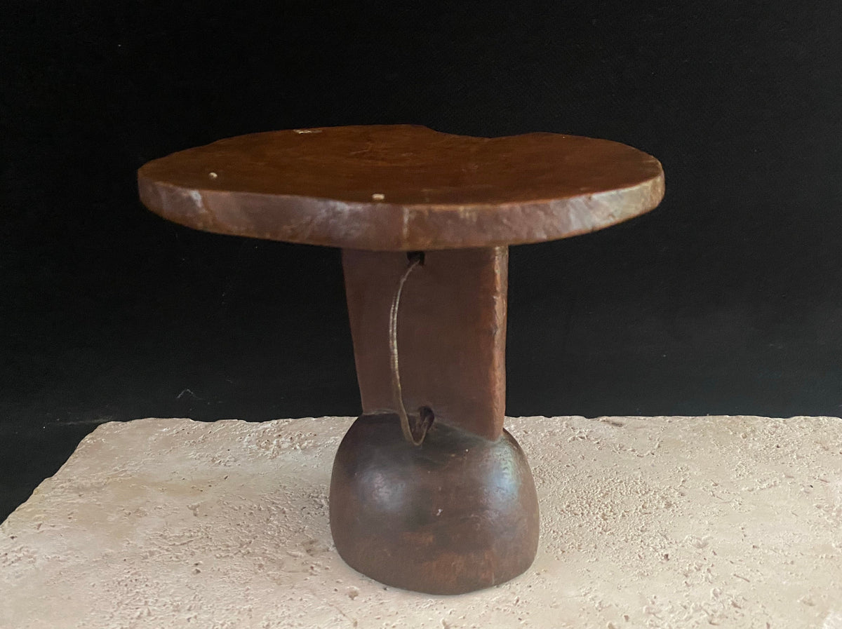 Mursi wood headrest, southern Ethiopia.   Carved from a single piece of wood, with cutouts. Vintage, late 20th century, with patina and wear appropriate to its age. A wire handle is attached. 15 cm height