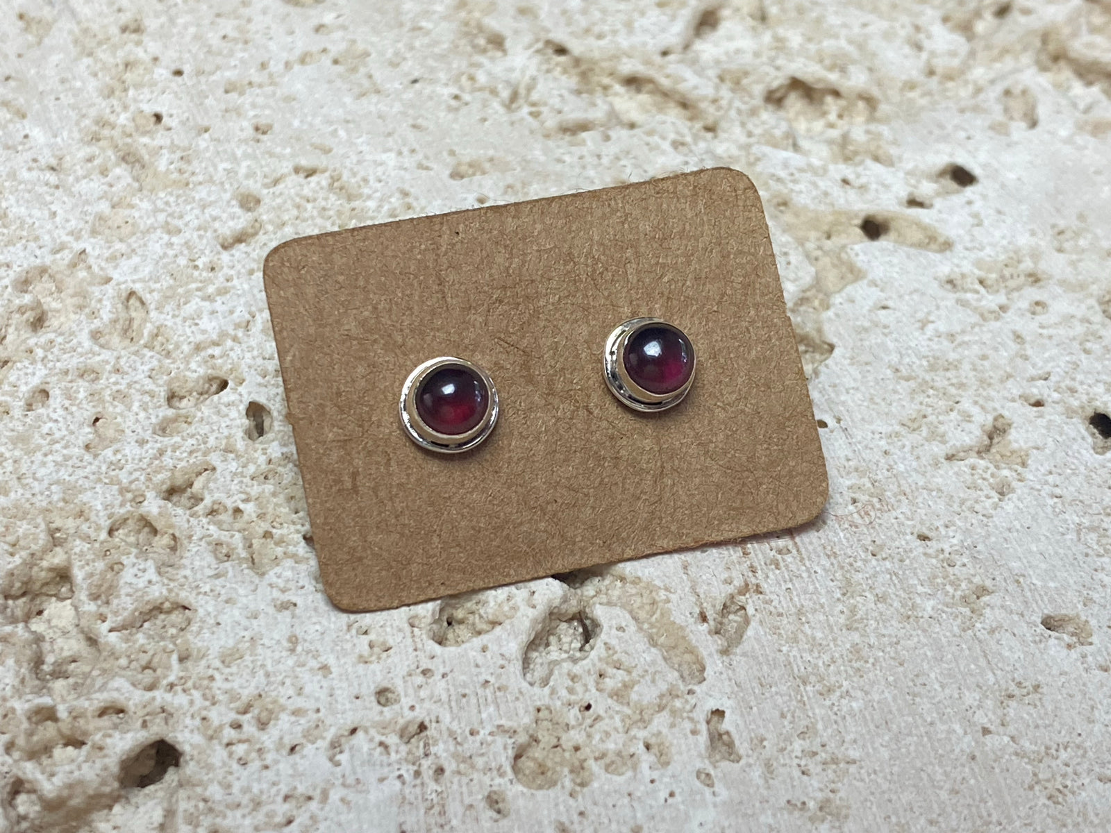 These small garnet studs are hand made from sterling silver and set with natural garnet cabochon stones
