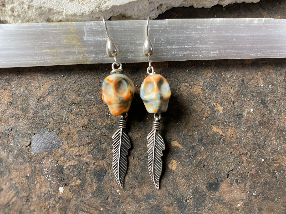 Skull jewelry. Hand carved jasper skull earrings feature sterling silver hooks and feather dangles. 