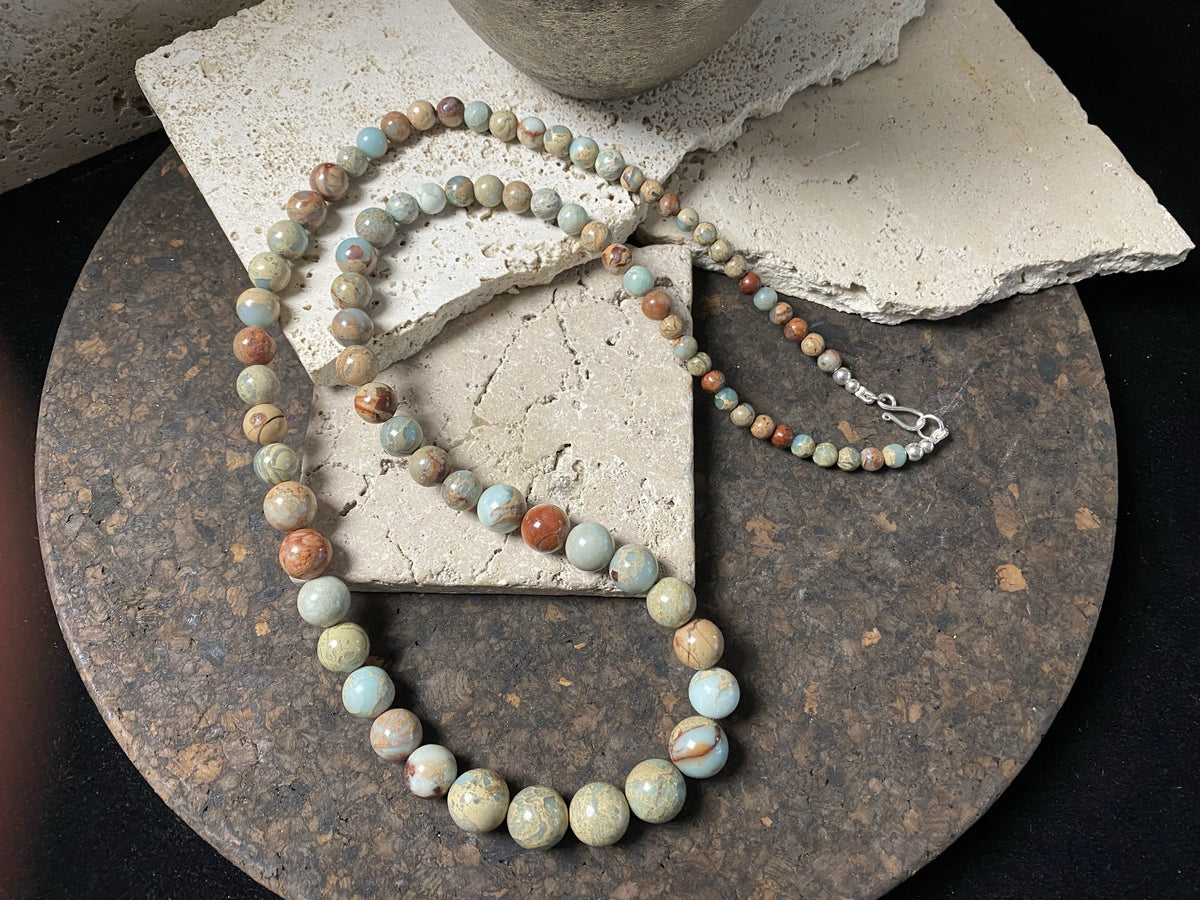 A long necklace made from perfectly matched, graduated Ethiopian opal beads, finished with sterling silver findings. Hook clasp. Measurements: 80 cm (31.5"), largest bead 14 mm diameter, smallest bead 6 mm diameter.