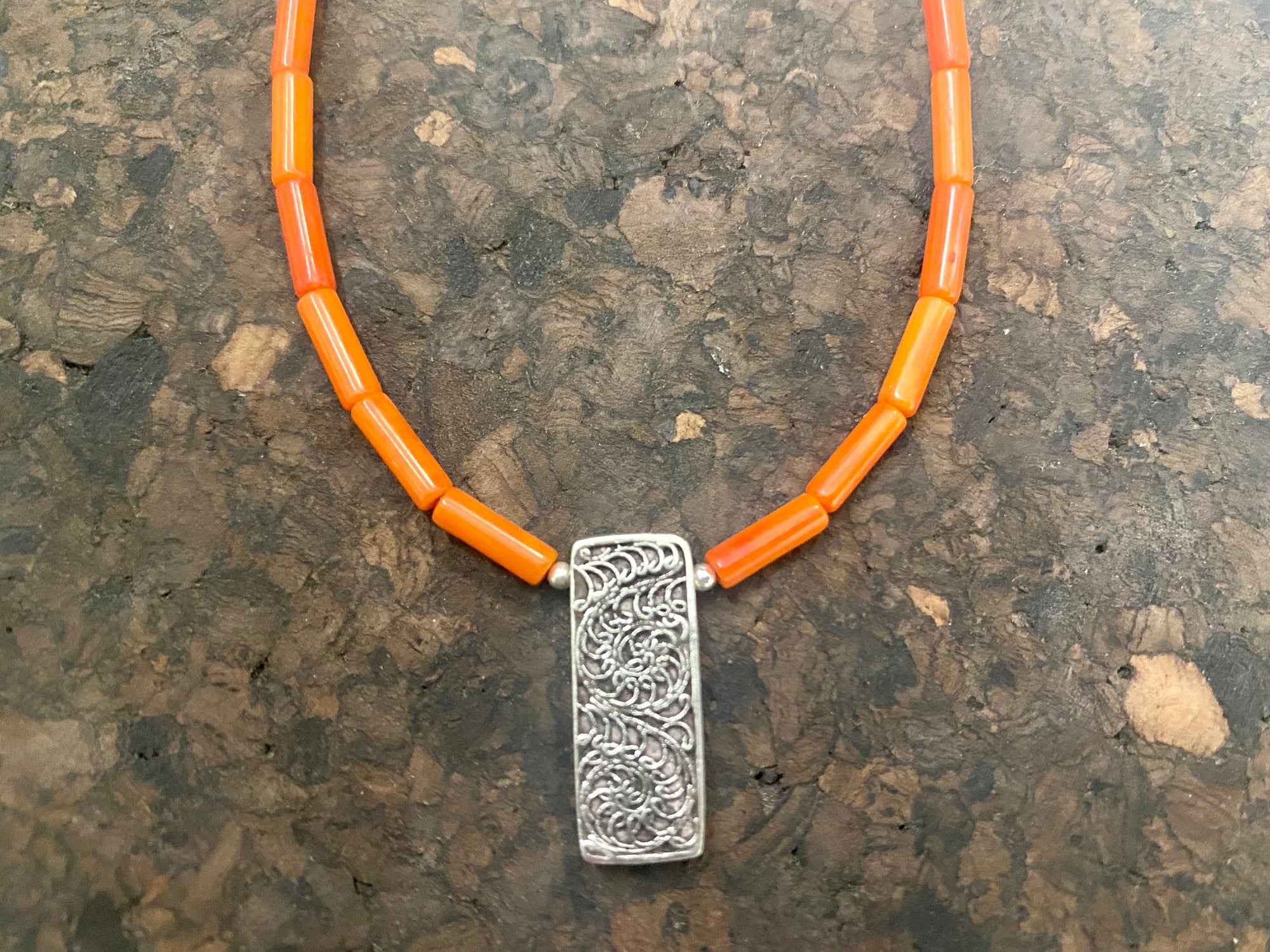 Orange-red coral necklace with sterling silver filigree pendant. Finished with l silver hook clasp. Length 45 cm
