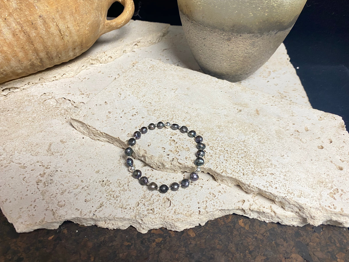 Grey black freshwater pearl bracelet with sterling silver bead detailing. Elasticised stringing for a seamless look. Length 19 cm