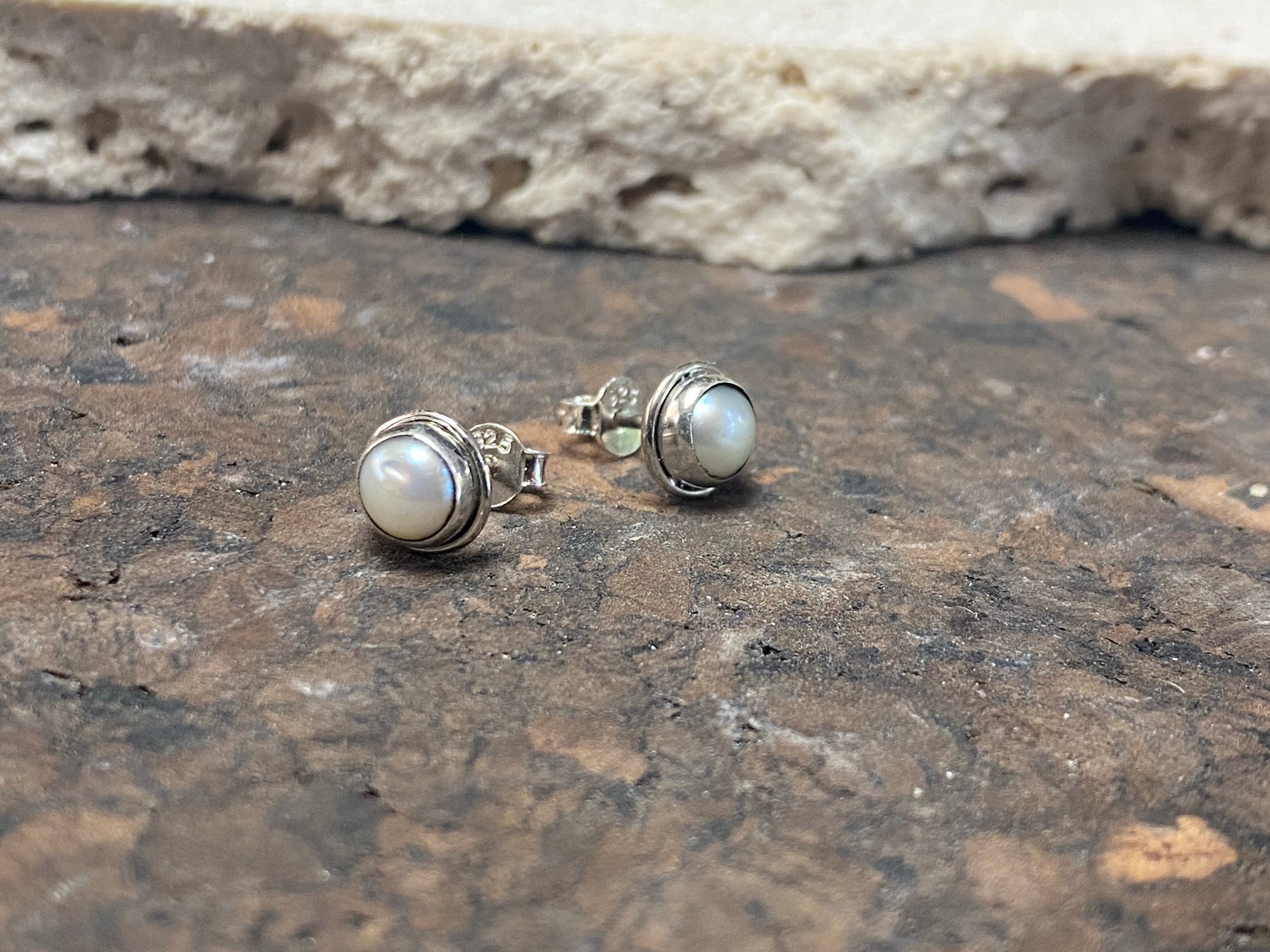 These small pearl studs are hand made from sterling silver and set with natural pearl cabochon stones