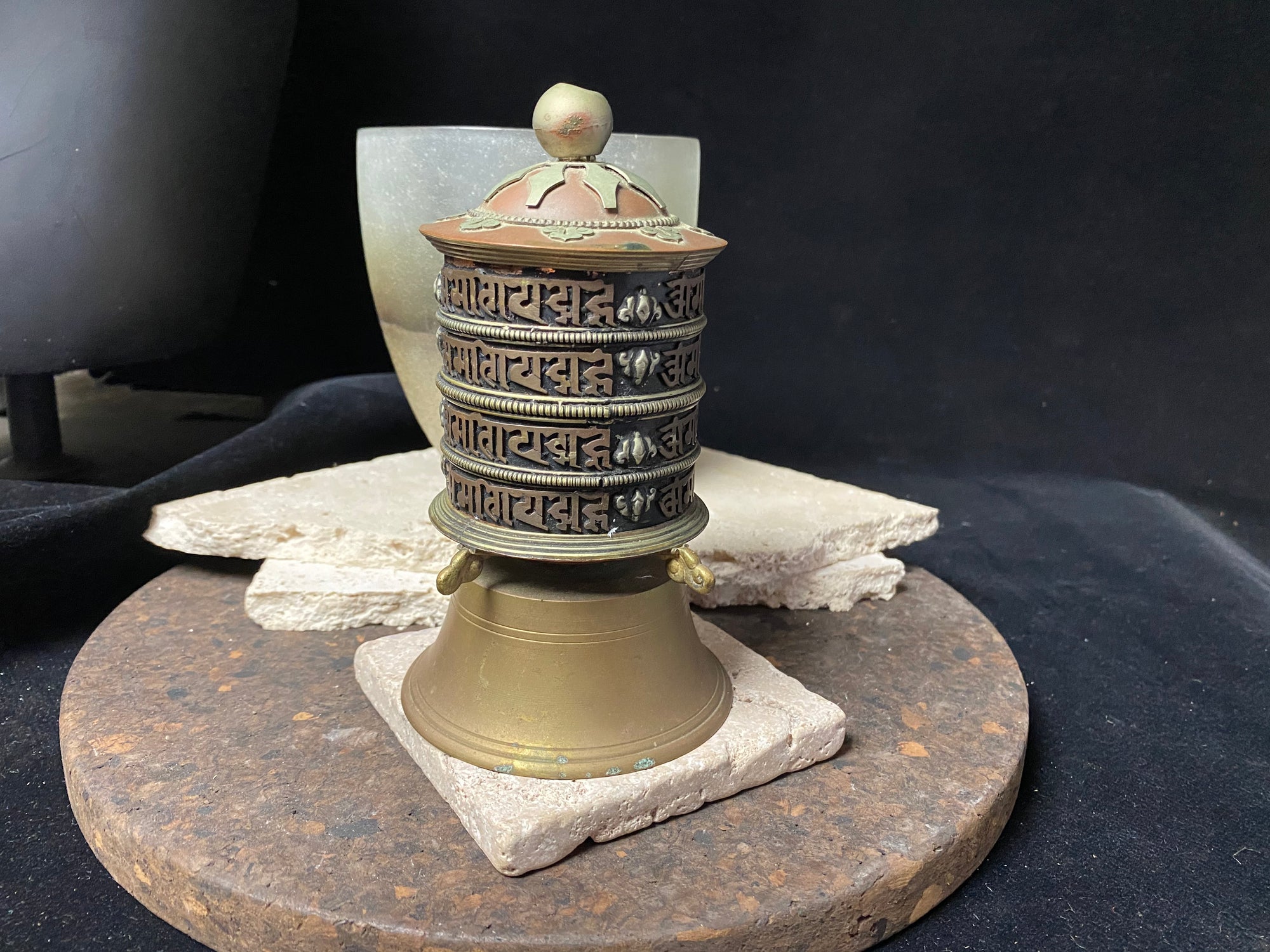 Handmade in Nepal from brass and copper, this standing prayer wheel is beautifully weighted for spinning and contains a scroll on which is printed the mantra "Om Mani Padme Hum", a prayer to the Compassionate Buddha, written many thousand times. 16 cm high