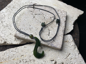 Natural green jade hei matau fish hook pendant, hand carved in New Zealand by a Maori craftsman.