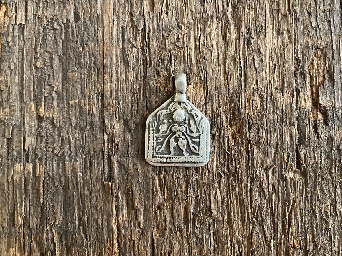 Antique silver amulets representing the Hindu god Kali, in her protective form, and dating from the early 19th - early 20th century.  Measurements: all vary between 1.5 and 2.2 cm in width