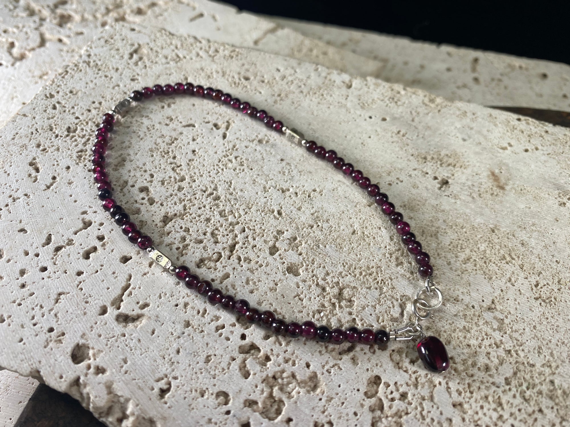 Gypsy anklets featuring natural garnet and sterling silver charms. Sterling silver clasps and detailing, with a garnet pendant that sits at the back of the anklet. Designed to sit gracefully around the foot rather than tight to the ankle. Select from three sizes