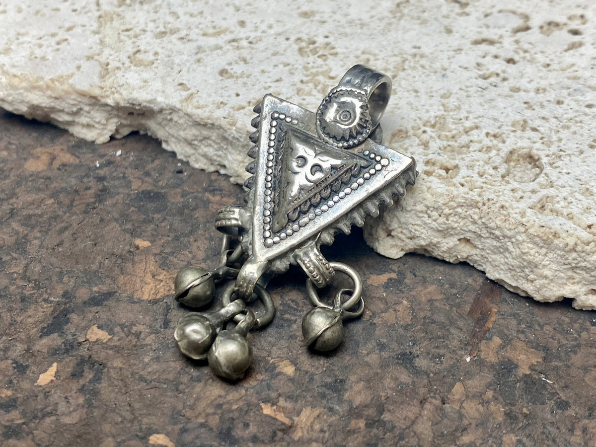 High grade silver pendant, late 19th century, Turkmenistan. It features bands of applied decorative work and a central hammered tree of life design. The pattern is repeated on both sides of the pendant. Length 6 cm