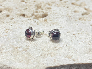 These small garnet studs are hand made from sterling silver and set with natural garnet cabochon stones
