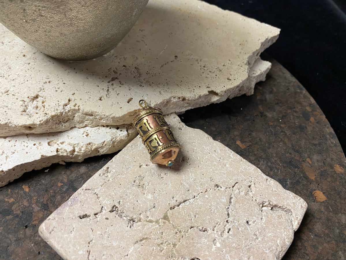 These copper and brass prayer boxes or amulets are designed to be worn as a pendant, or added to a keyring. Contains a prayer scroll withthe mantra to the Compassionate Buddha Om Mani Padme Hum , 4.5 cm length