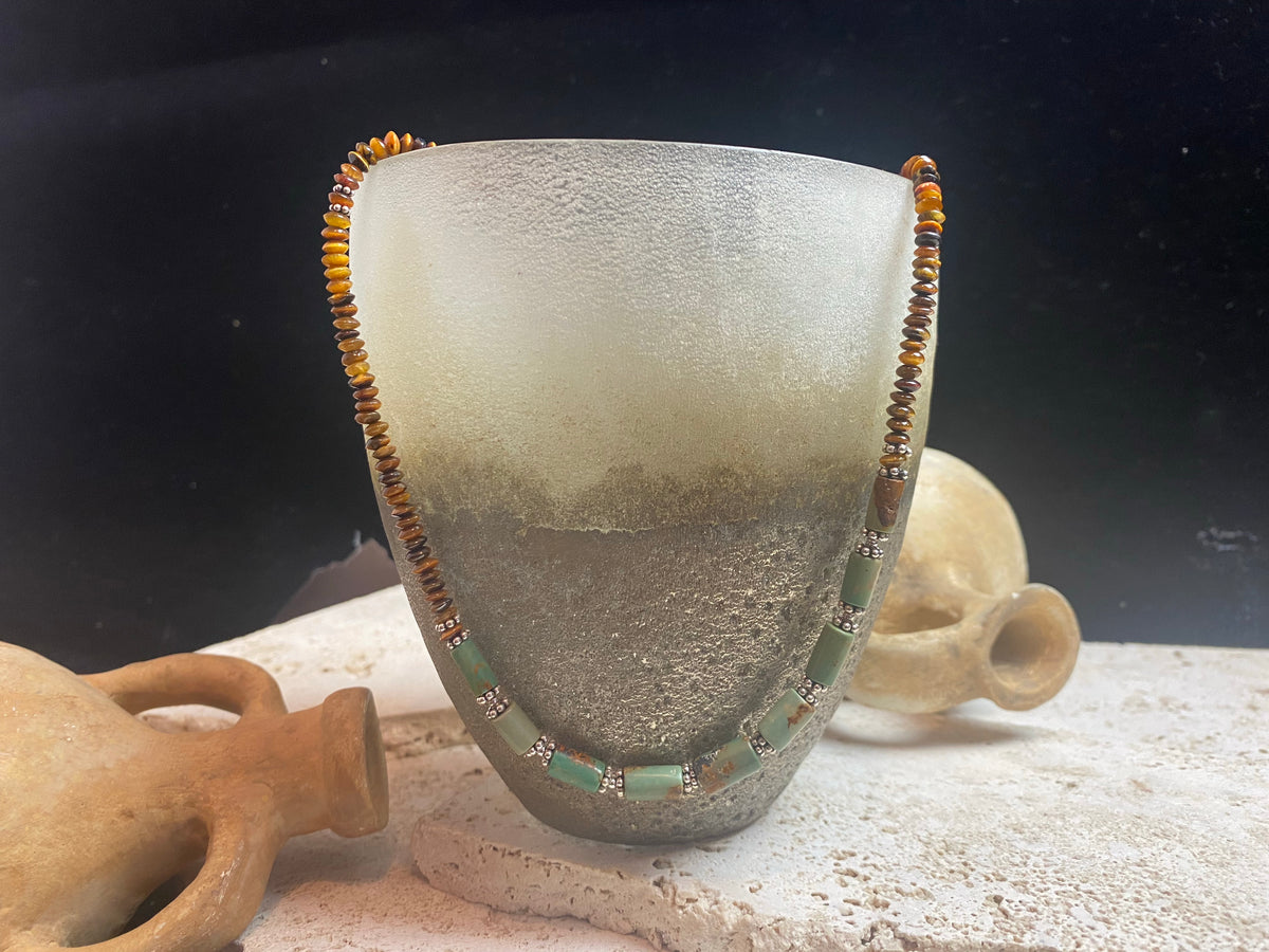 Dirty, natural blue-green turquoise beads teamed with saucer-cut natural tigers eye. Sterling silver clasp and detailing. This statement necklace has a distinctive Southwest vibe and is designed to be worn by men or women. Length 49 cm