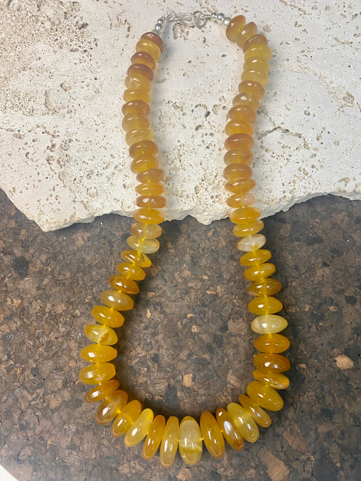 A beautiful necklace of polished graduated caramel onyx beads. Sterling silver clasp and detailing. This statement necklace is designed to impress, with the look of high quality amber without the price tag. length 51.5 cm