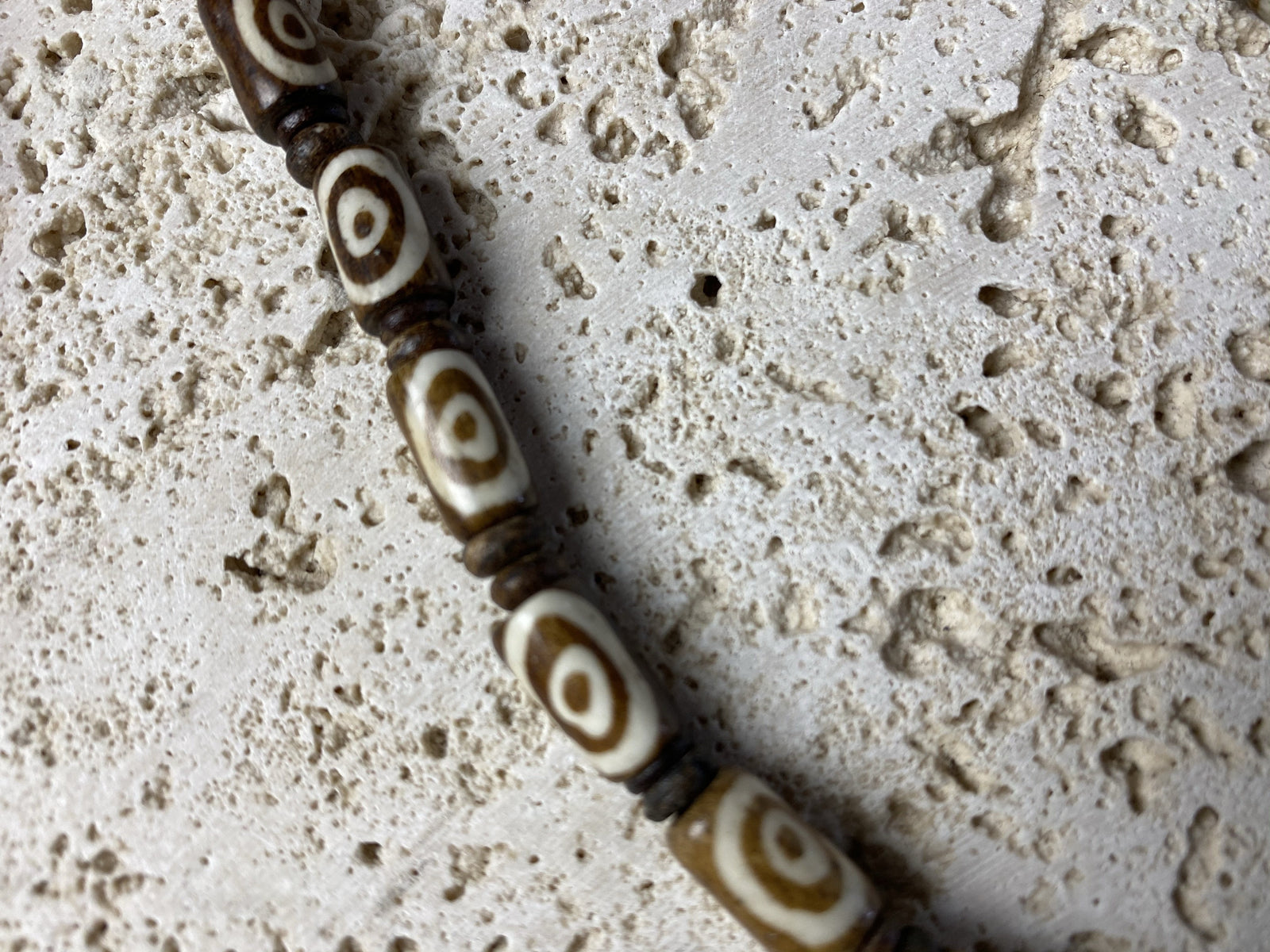 Beach vibe surfer necklace made from brown etched cow bone tube beads and coconut wood spacers with brass screw clasp