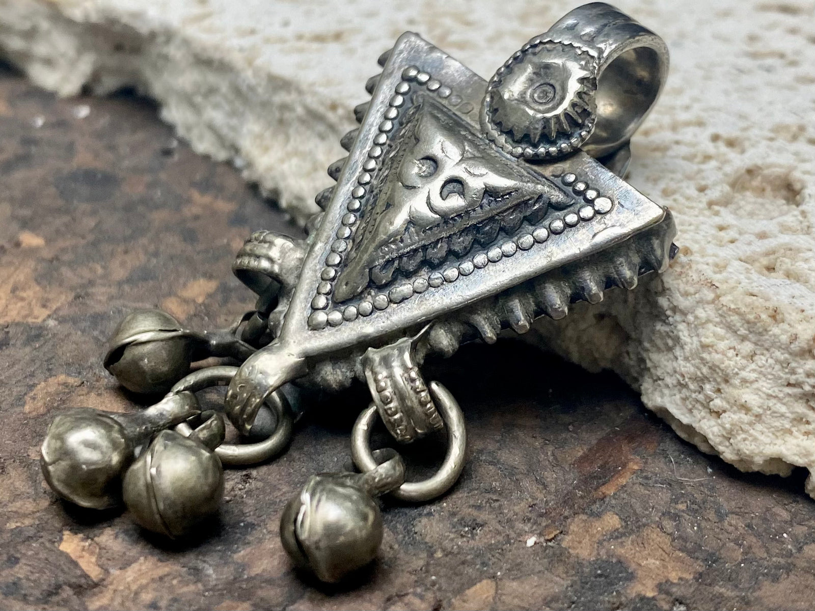 High grade silver pendant, late 19th century, Turkmenistan. It features bands of applied decorative work and a central hammered tree of life design. The pattern is repeated on both sides of the pendant. Length 6 cm