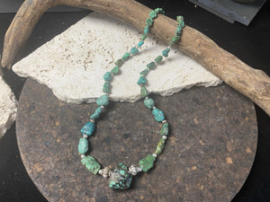 A unique necklace crafted from graduated antique Tibetan turquoise and vintage silver beads, highlighted with sterling silver spacer beads. These beautiful natural stones range in colour from mid to dark blue-green and are all antiques in their own right. The best turquoise we've ever found.  This long tribal necklace can be worn by either men or woman. Total length 62.7 cm