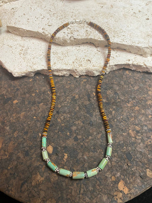 Dirty, natural blue-green turquoise beads teamed with saucer-cut natural tigers eye. Sterling silver clasp and detailing. This statement necklace has a distinctive Southwest vibe and is designed to be worn by men or women. Length 49 cm