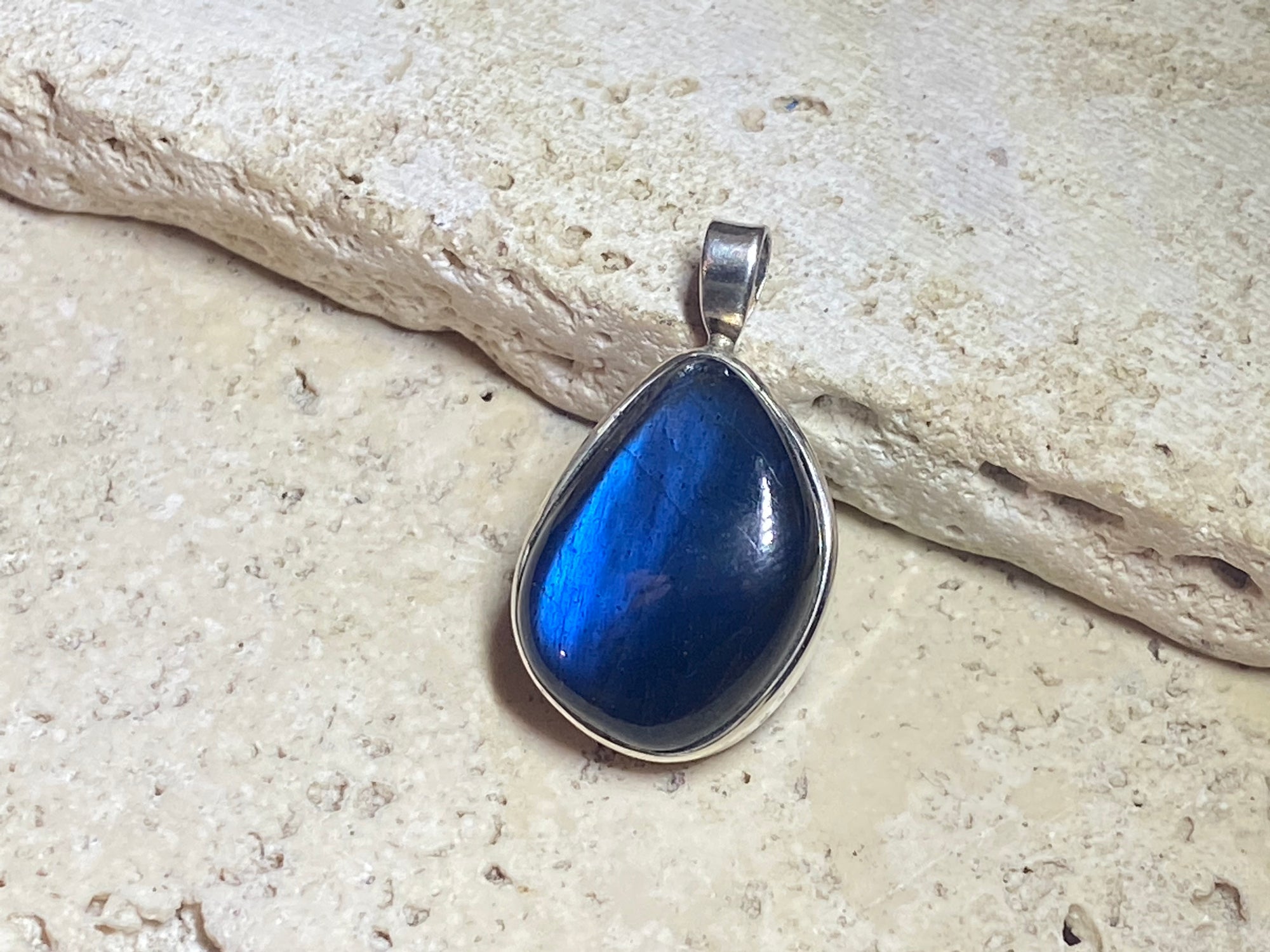 Stunning free form labradorite pendant set in sterling silver with a generous bail to take a large chain or cord. A quality stone with dark blue colour.