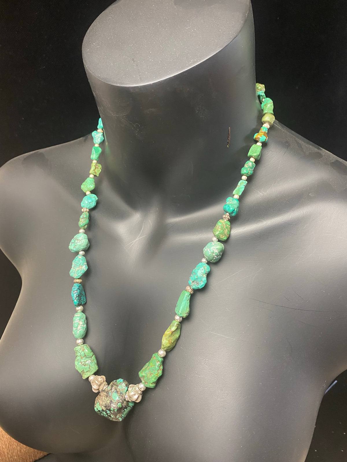 A unique necklace crafted from graduated antique Tibetan turquoise and vintage silver beads, highlighted with sterling silver spacer beads. These beautiful natural stones range in colour from mid to dark blue-green and are all antiques in their own right. The best turquoise we've ever found.  This long tribal necklace can be worn by either men or woman. Total length 62.7 cm