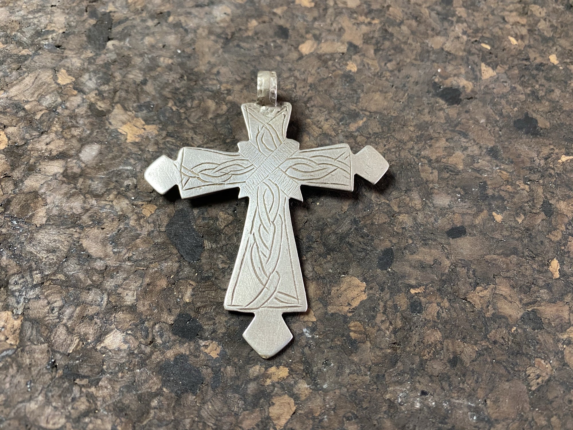 Early 20th century Ethiopian silver cross, most likely cut from a Marie Therese Thaler. Silver, with a simple engraved decoration on each side and light wear at the head of the bail,  total height including bail 7.5 cm (3")
