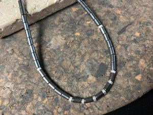 Hematite unisex necklace of tube beads highlighted with sterling silver detailing and finished with a sterling silver hook clasp. Can be worn by men or women.  Natural hematite necklace. Length 44.4 cm (17.5")