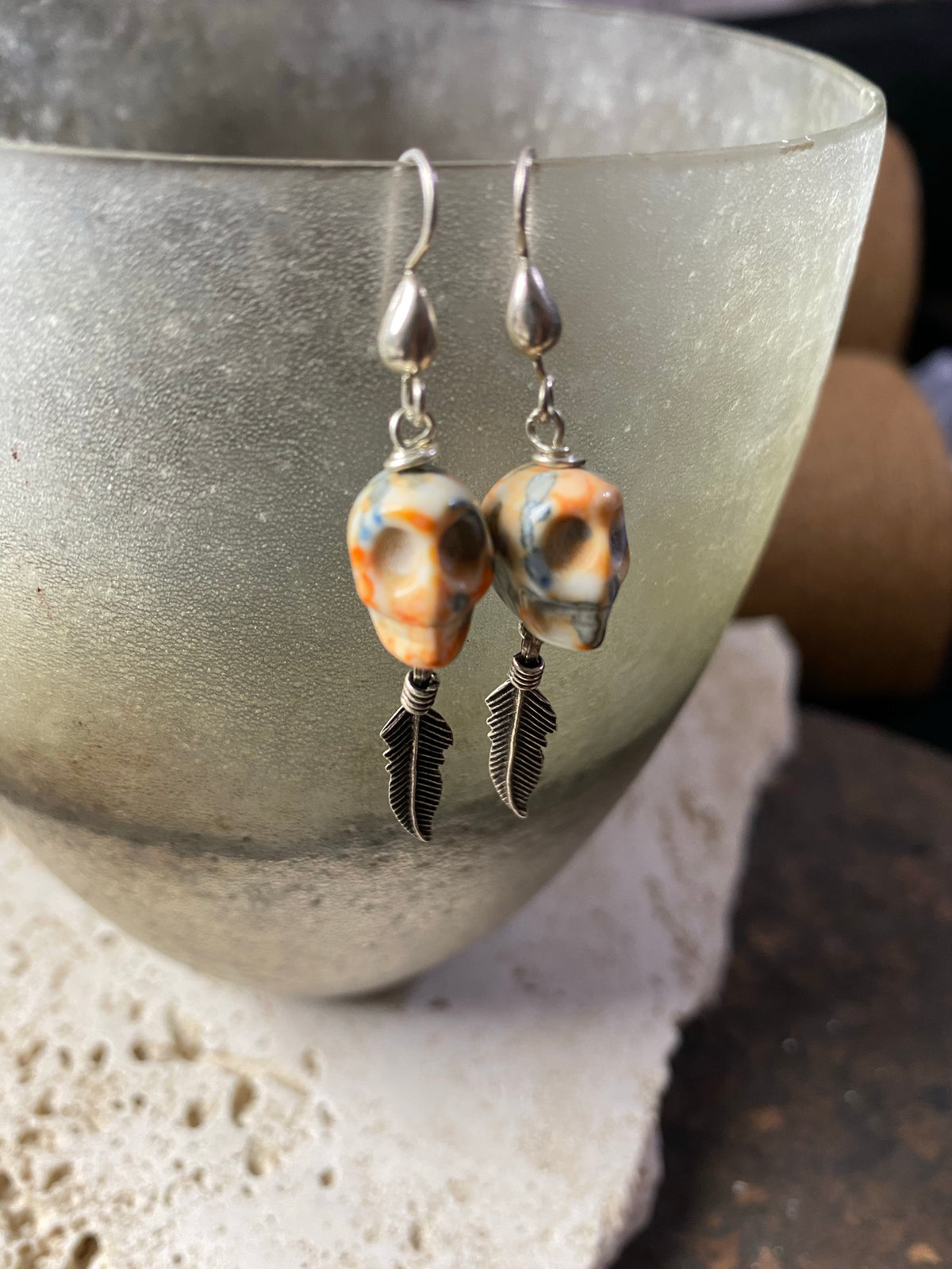 Skull jewelry. Hand carved jasper skull earrings feature sterling silver hooks and feather dangles. 