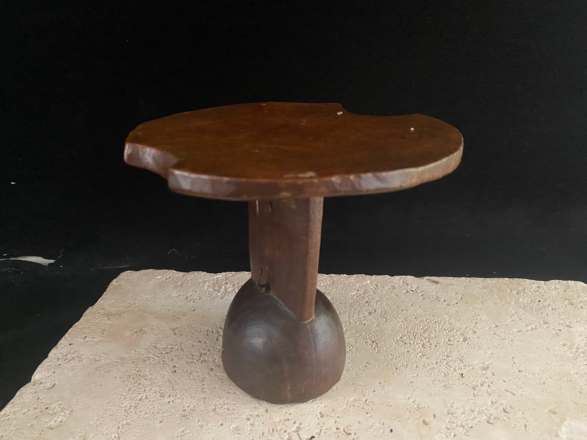 Mursi wood headrest, southern Ethiopia.   Carved from a single piece of wood, with cutouts. Vintage, late 20th century, with patina and wear appropriate to its age. A wire handle is attached. 15 cm height