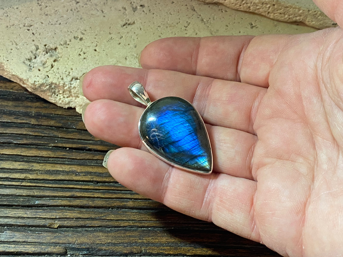 Stunning upside-down teardrop labradorite pendant set in sterling silver with a generous bail to take a large chain or cord. A stunning, high quality stone with excellent blue colour and fire.