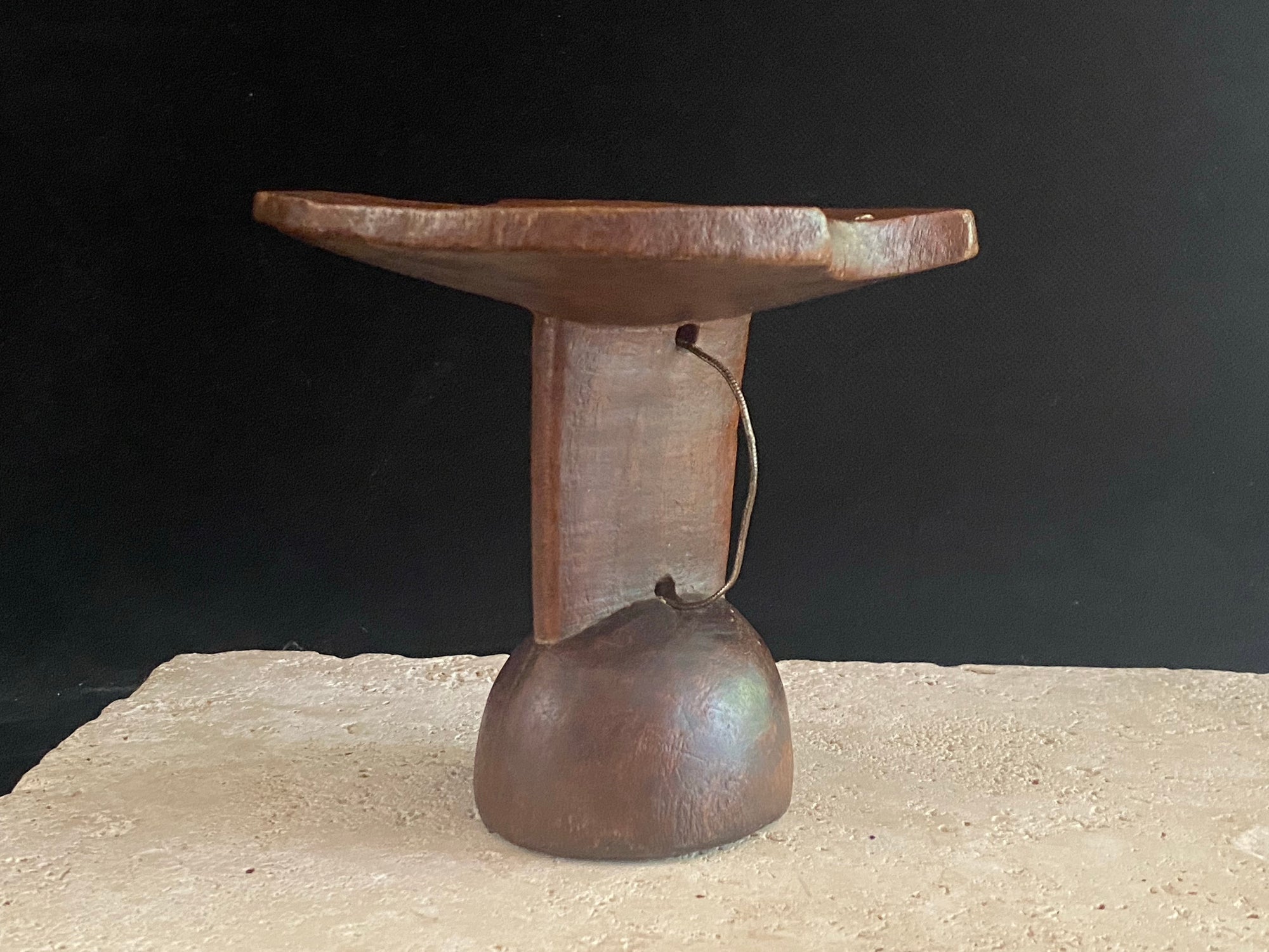 Mursi wood headrest, southern Ethiopia.   Carved from a single piece of wood, with cutouts. Vintage, late 20th century, with patina and wear appropriate to its age. A wire handle is attached. 15 cm height