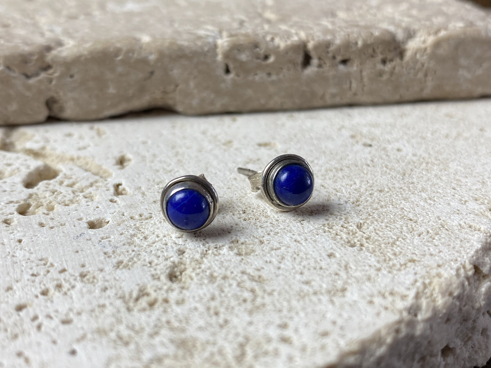 Simple and elegant, these small lapis lazuli earring studs are hand made from sterling silver and set with lapis cabochons